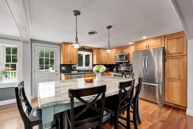 7 Perkins Row, Topsfield, MA 01983 - kitchen featuring stainless steel appliances, decorative backsplash, a breakfast bar, light stone countertops, and recessed lighting