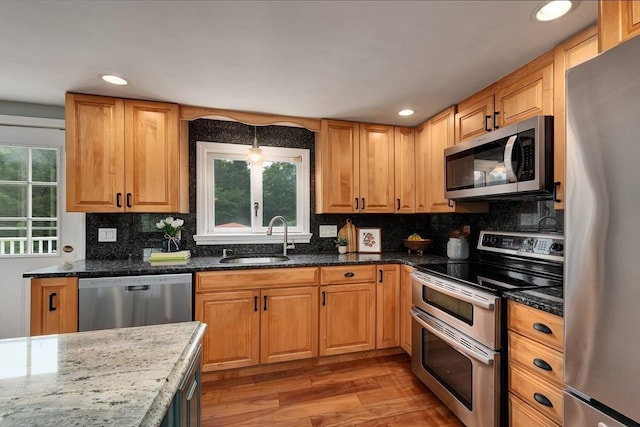 7 Perkins Row, Topsfield, MA 01983 - kitchen featuring appliances with stainless steel finishes, light wood-type flooring, tasteful backsplash, dark stone countertops, and recessed lighting