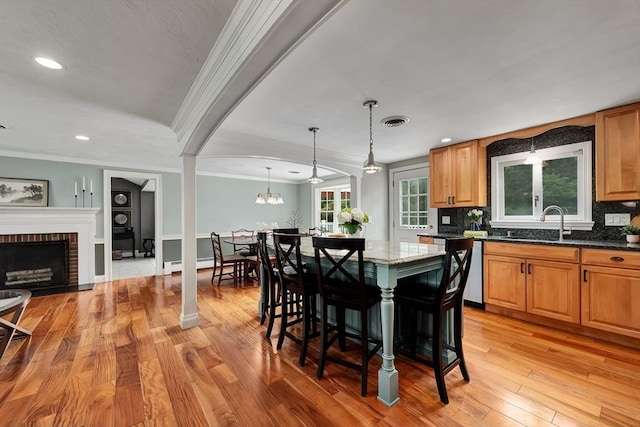 7 Perkins Row, Topsfield, MA 01983 - kitchen with crown molding, light wood-type flooring, a chandelier, decorative backsplash, and dark stone counters