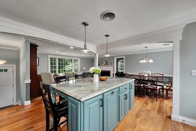 7 Perkins Row, Topsfield, MA 01983 - kitchen featuring blue cabinetry, light wood-style floors, a fireplace, crown molding, and open floor plan