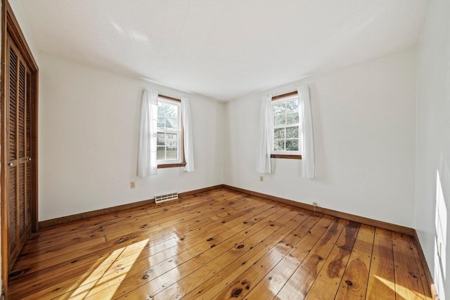 empty room featuring baseboards and hardwood / wood-style flooring