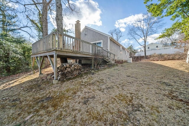 rear view of property featuring a deck, stairway, and a chimney