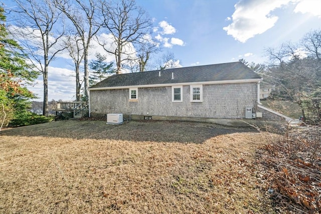 back of house featuring a chimney and a lawn