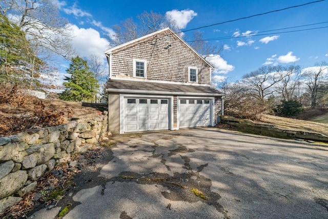 view of side of property featuring driveway and a garage