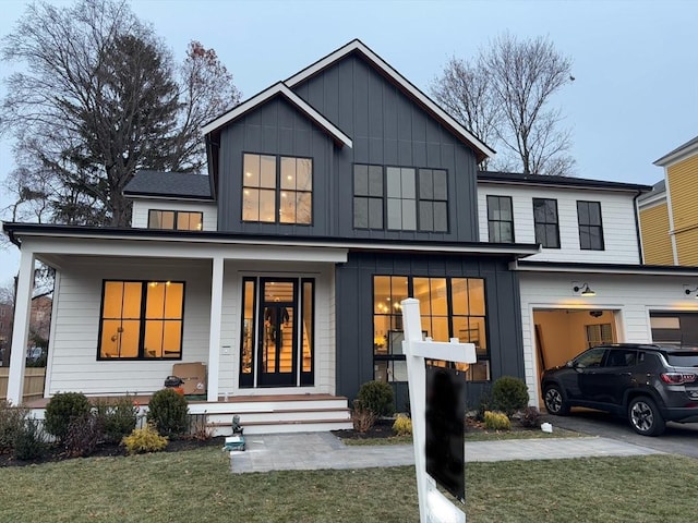 modern farmhouse style home with a porch and a front yard