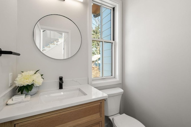 bathroom featuring vanity, toilet, and a wealth of natural light