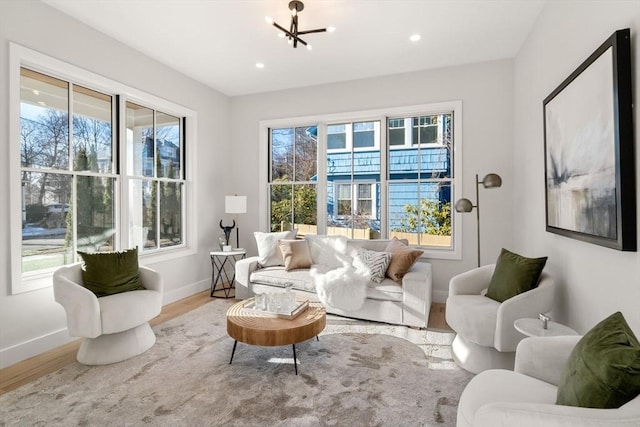 sitting room with a chandelier, wood-type flooring, and a wealth of natural light