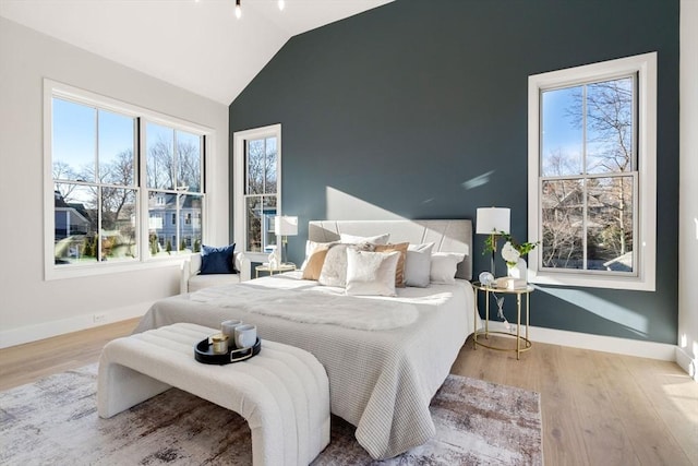 bedroom with vaulted ceiling and light hardwood / wood-style flooring