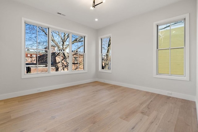 spare room with a healthy amount of sunlight and light hardwood / wood-style floors