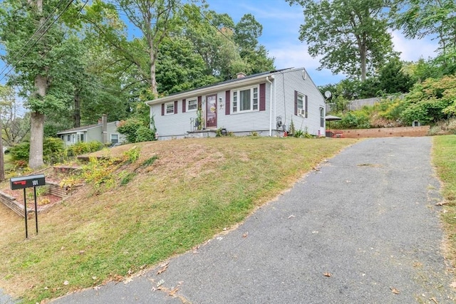 single story home with driveway and a front lawn