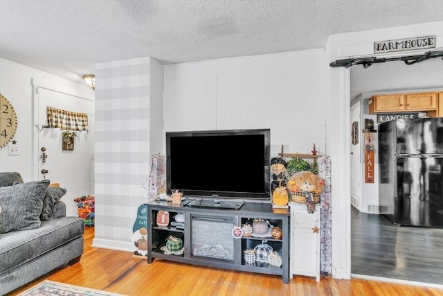 living area with a textured ceiling and wood finished floors