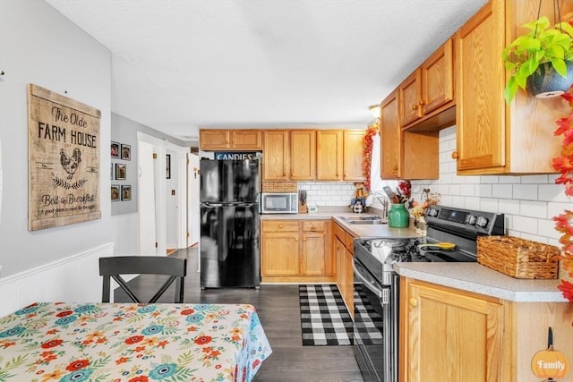 kitchen featuring dark wood-style floors, appliances with stainless steel finishes, light countertops, and a sink