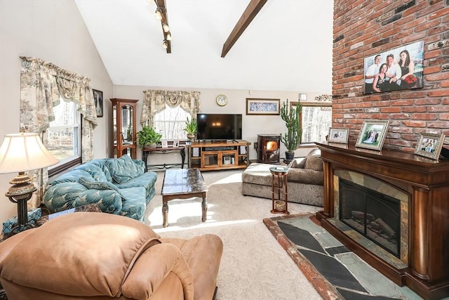 living room with carpet flooring, rail lighting, high vaulted ceiling, beamed ceiling, and a fireplace