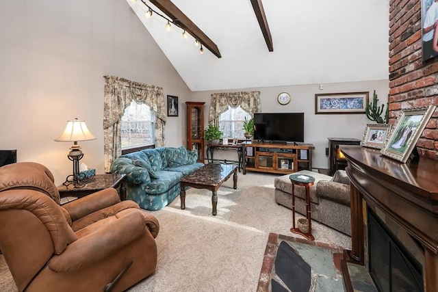 carpeted living room featuring a fireplace, track lighting, and high vaulted ceiling