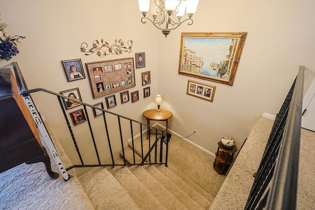 staircase featuring carpet flooring and an inviting chandelier