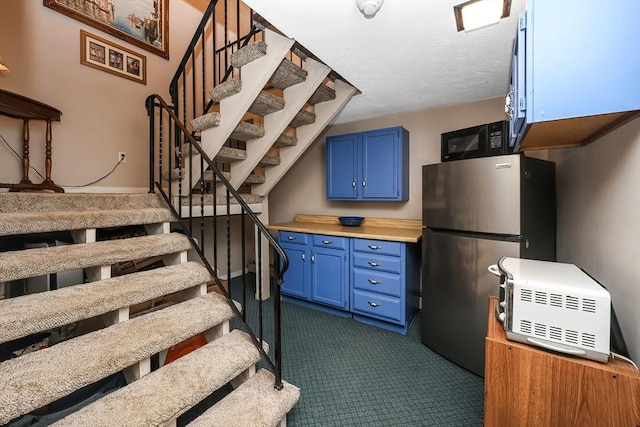 stairway with carpet and a textured ceiling