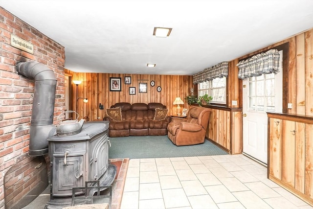 living room with a wood stove, wooden walls, and light carpet