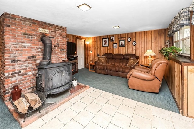 carpeted living room featuring a wood stove and wood walls