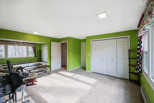 interior space with light colored carpet and baseboard heating