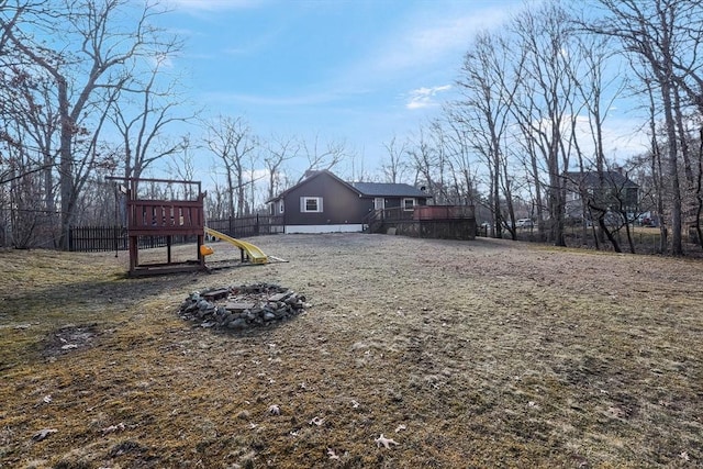 view of yard featuring a fire pit, a deck, and a playground