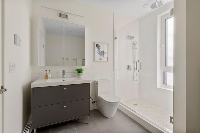 bathroom with tile patterned flooring, vanity, a shower with door, and a healthy amount of sunlight