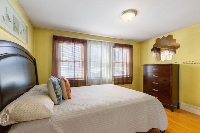 bedroom with multiple windows and light wood-type flooring