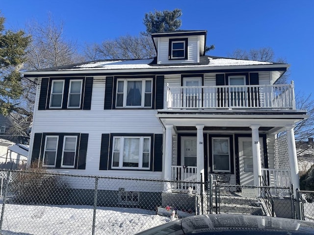 view of front facade with covered porch, a fenced front yard, and a balcony