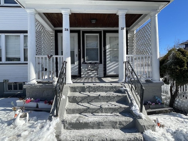 snow covered property entrance featuring covered porch