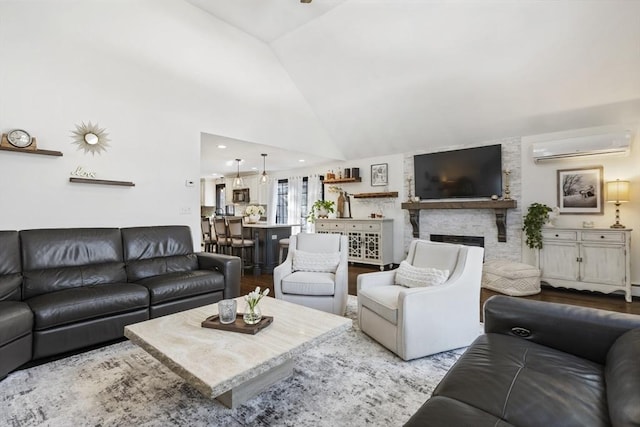 living room featuring an AC wall unit, high vaulted ceiling, a stone fireplace, and light wood-type flooring