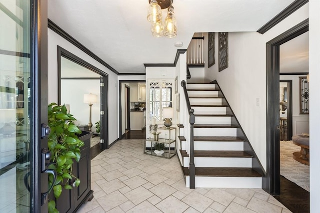 entrance foyer with crown molding and a notable chandelier