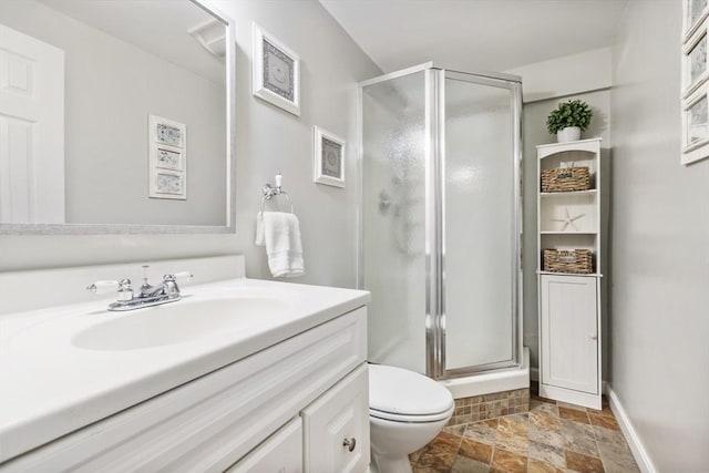 bathroom featuring vanity, toilet, and a shower with door