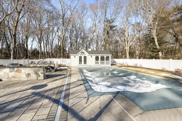 view of pool with an outdoor structure, exterior bar, an outdoor kitchen, and a patio area