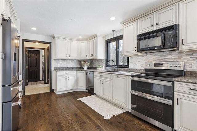 kitchen with sink, dark hardwood / wood-style flooring, pendant lighting, stainless steel appliances, and backsplash