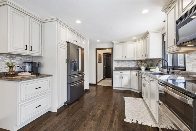 kitchen featuring stainless steel appliances, white cabinetry, sink, and dark hardwood / wood-style floors