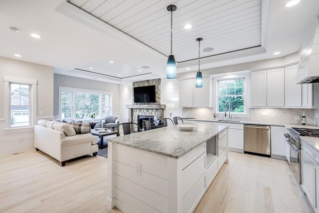 24 Valley Rd, Yarmouth, MA 02673 - kitchen with a raised ceiling, appliances with stainless steel finishes, a center island, white cabinetry, and pendant lighting