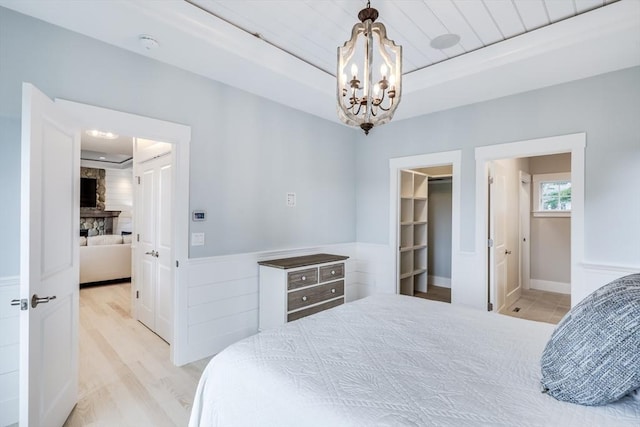 24 Valley Rd, Yarmouth, MA 02673 - bedroom featuring light wood finished floors, connected bathroom, a spacious closet, and a notable chandelier