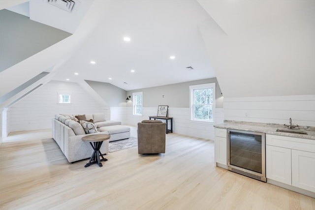 24 Valley Rd, Yarmouth, MA 02673 - living room featuring light wood finished floors, visible vents, lofted ceiling, wine cooler, and indoor wet bar