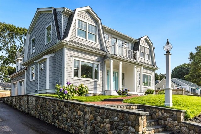 24 Valley Rd, Yarmouth, MA 02673 - shingle-style home with a porch, a balcony, a garage, a gambrel roof, and a front lawn