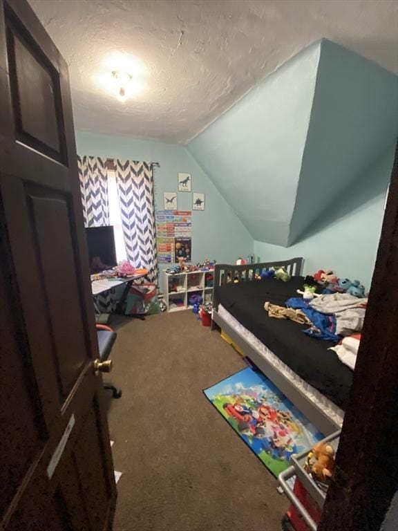 carpeted bedroom featuring lofted ceiling and a textured ceiling