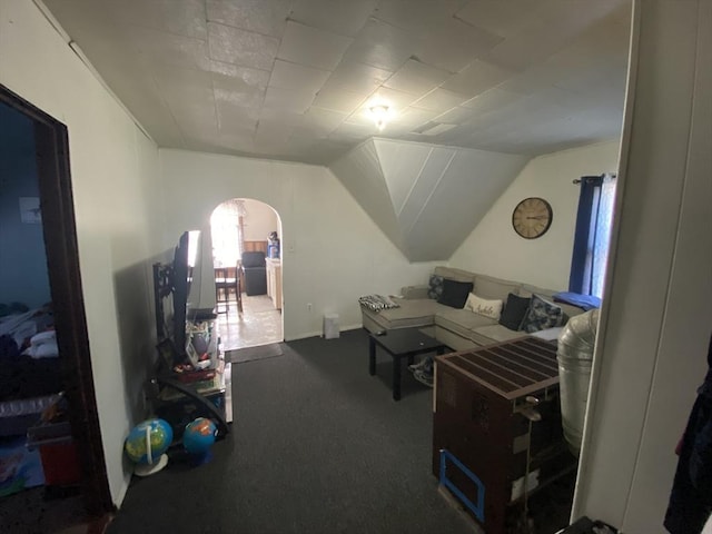 bonus room featuring arched walkways, lofted ceiling, and carpet floors