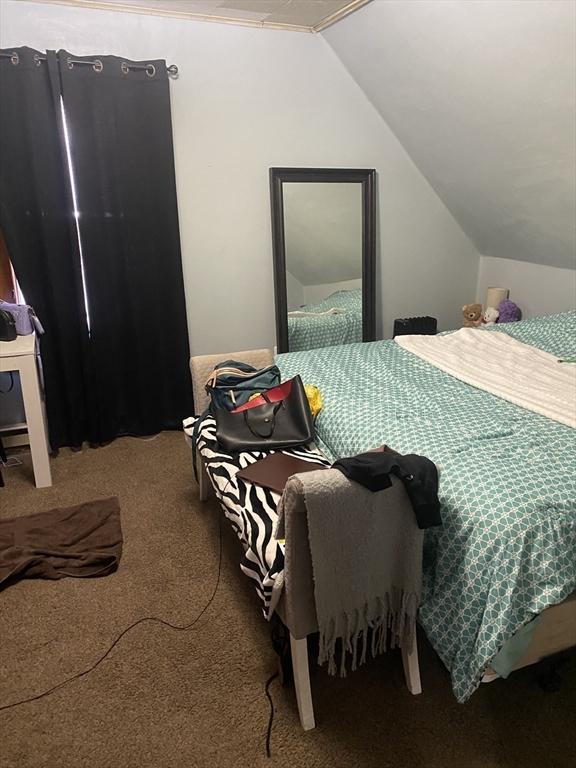 carpeted bedroom with lofted ceiling