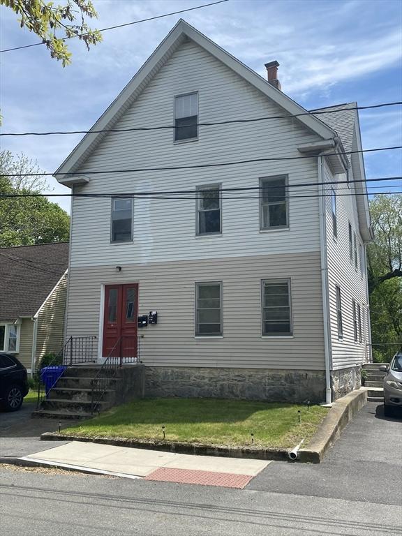 view of front of house with a chimney and a front lawn