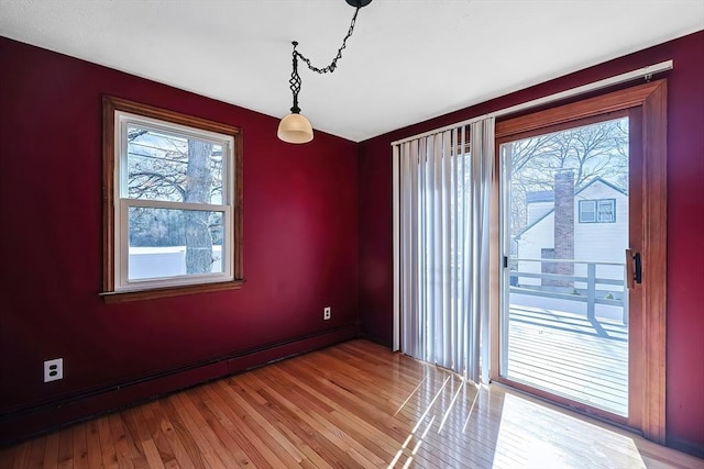 empty room with light wood-type flooring and a baseboard heating unit