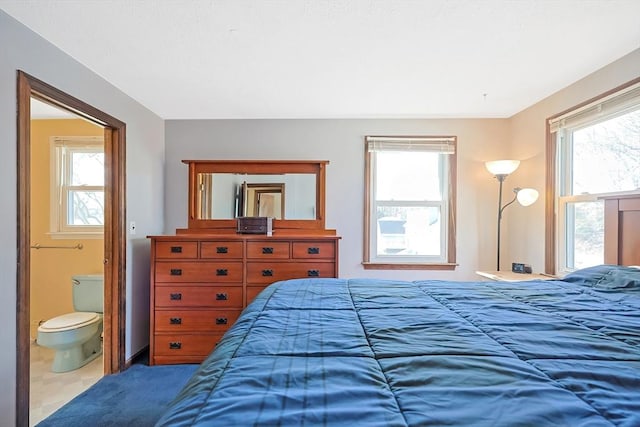 bedroom featuring connected bathroom and multiple windows