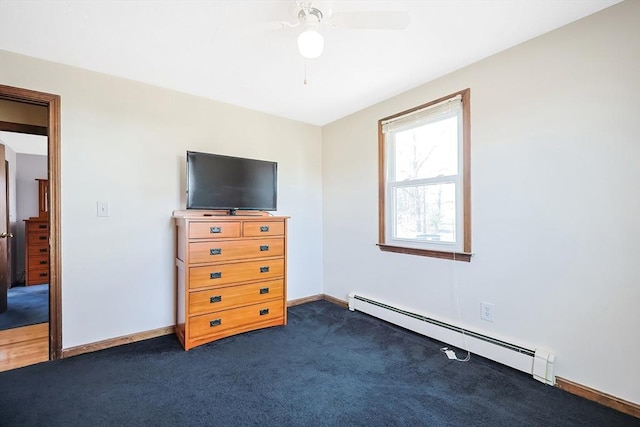 unfurnished bedroom with dark carpet, baseboards, baseboard heating, and ceiling fan