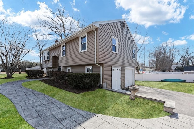 view of side of home with fence, a chimney, a garage, a yard, and driveway