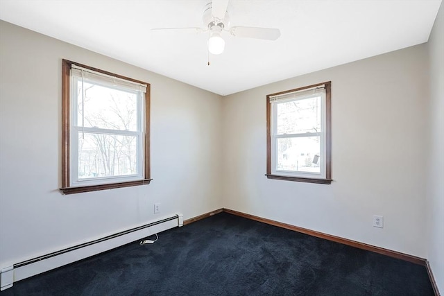 unfurnished room featuring dark colored carpet, a baseboard heating unit, baseboards, and a ceiling fan