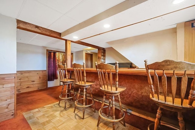 bar with a wainscoted wall, recessed lighting, wood walls, carpet flooring, and a dry bar