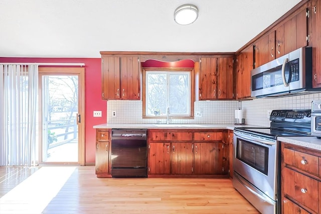 kitchen with a sink, stainless steel appliances, a wealth of natural light, and light countertops