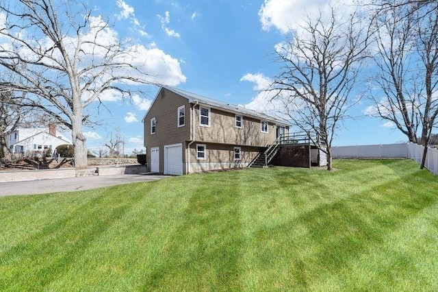 rear view of house with stairway, a lawn, driveway, and a garage